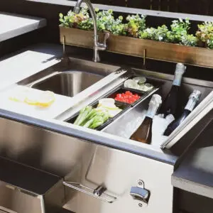 Modern kitchen sink with plants and organized utensils.