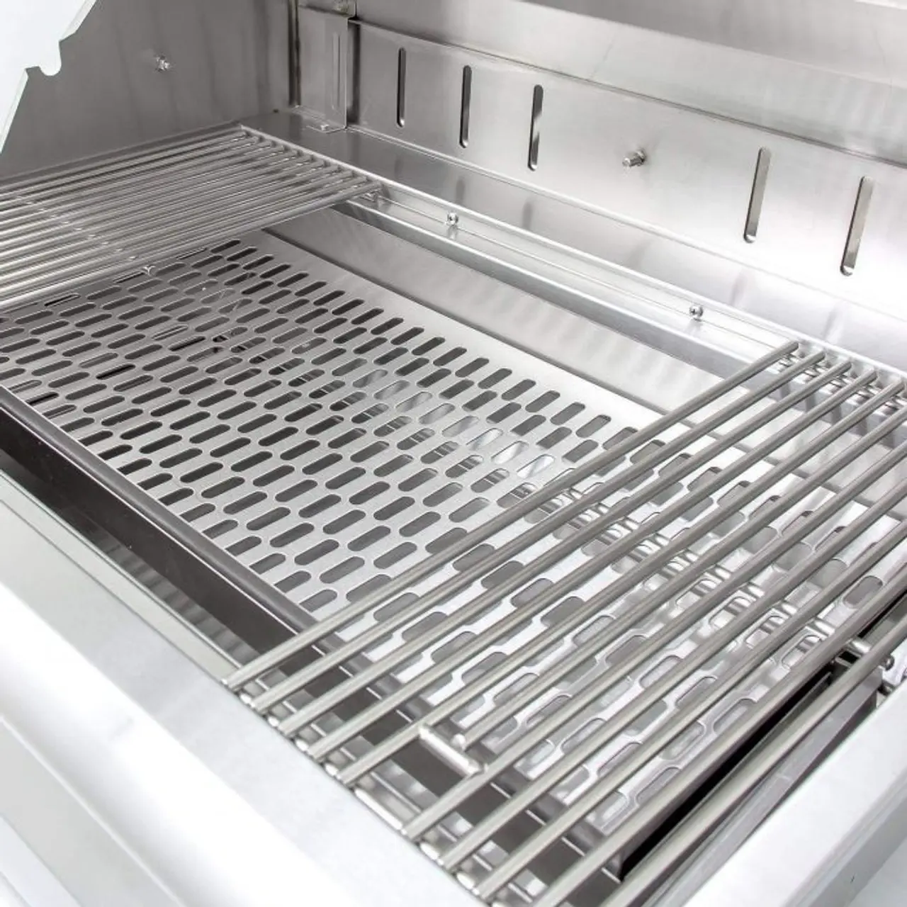 Stainless steel grill grates inside a clean grill.